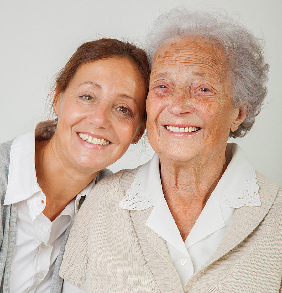 Smiling senior woman with caregiver representing compassionate in-home senior care and family support
