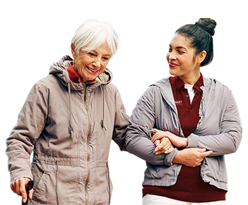 Senior companion care with an older woman walking alongside a caregiver, supporting engagement and peace of mind